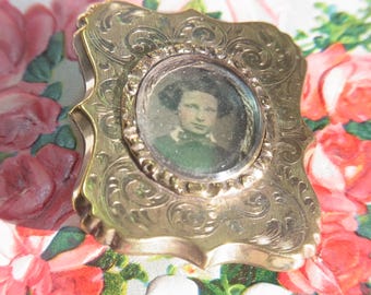 Broche de luto victoriano antiguo en tono dorado con fotografía de una joven. Joya conmemorativa de mediados y finales del siglo XIX. Prende con valor sentimental.