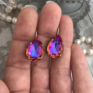 May include: A pair of teardrop-shaped earrings with iridescent purple and orange crystals.