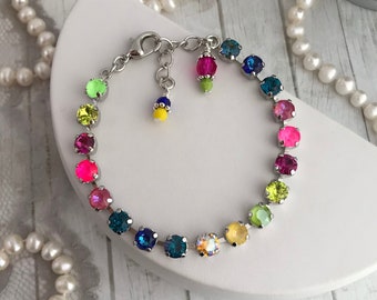 May include: A rainbow-coloured crystal bracelet with a silver chain and clasp. The bracelet features a variety of colourful crystals, including red, orange, yellow, green, blue, and purple.