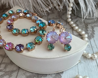 Pode incluir: Um conjunto de joias de ouro rosa com um colar e brincos. O colar é feito de pequenas pedras iridescentes em tons de azul, verde e roxo. Os brincos são um par correspondente de pedras iridescentes em um tom roxo claro.