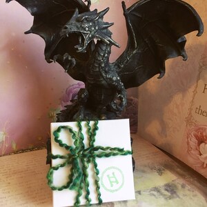 May include: A black dragon statue with outstretched wings stands behind a white gift box tied with green yarn. The box has a green logo and the text "Free Gift Boxing!"