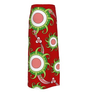 May include: A red skirt featuring a repeating pattern of stylized floral designs. The flowers have a central pink circle, surrounded by a white ring and green, petal-like shapes. Pink and white curved lines and small floral accents complete the design.
