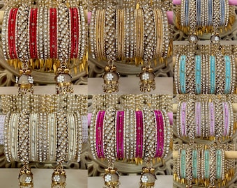 May include: A set of ten colorful bangles with gold accents and sparkling rhinestones. Each bangle is adorned with a small, dangling bell charm.
