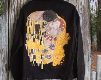 May include: A black denim jacket with a painting of Gustav Klimt's "The Kiss" on the back.