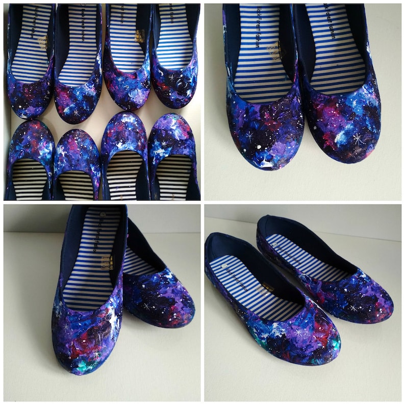 May include: A pair of navy blue canvas flats with a galaxy print. The print features a dark blue background with white stars, purple and pink nebulae, and a hint of green.