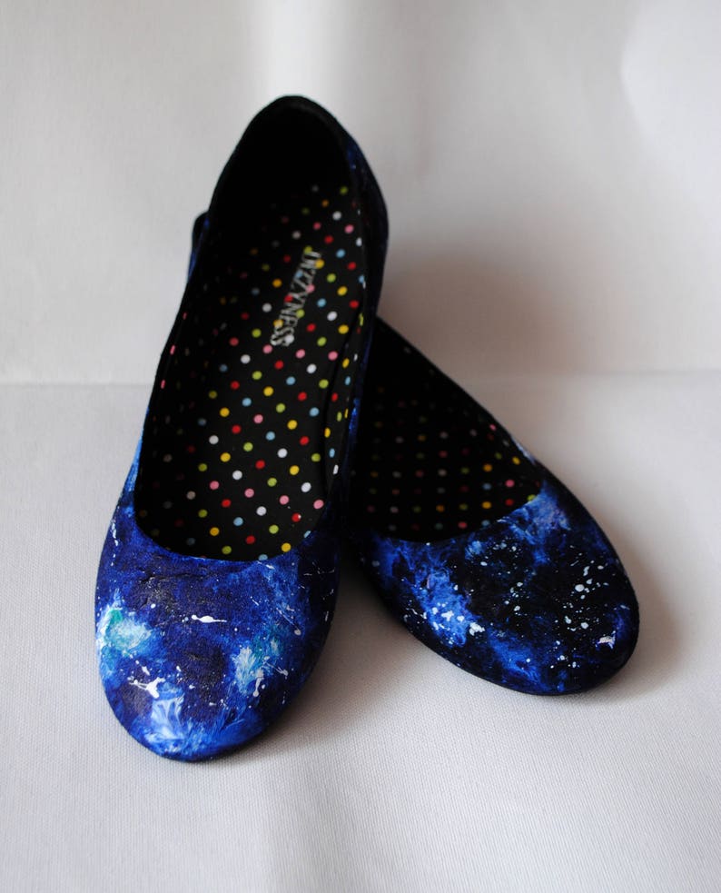 K&ouml;nnte beinhalten: Ein Paar blaue Canvas-Ballerinas mit Galaxie-Druck. Das Innere der Schuhe ist schwarz mit wei&szlig;en Punkten und der Text "Senses" ist auf der Innensohle gedruckt.