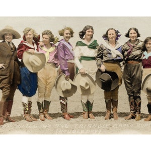 May include: A group of eight women wearing cowboy hats and boots, posing for a photo. They are all smiling and looking at the camera. The women are wearing a variety of colorful clothing, including a red jacket, a purple shirt, and a blue shirt. The photo is captioned "Cow Girls at the Triangle Ranch Rodeo (Double Day)".