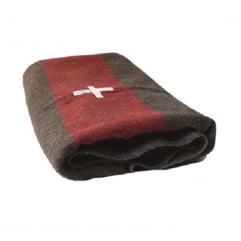 May include: A red and gray wool blanket with a white cross in the center. The blanket is folded in half and is lying on a white background.