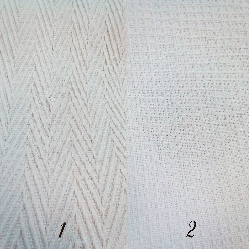 Puede incluir: Dos muestras de tela blanca con diferentes texturas. La muestra de la izquierda tiene un patr&oacute;n de espiga. La muestra de la derecha tiene un patr&oacute;n tejido. Las muestras est&aacute;n etiquetadas con 1 y 2.