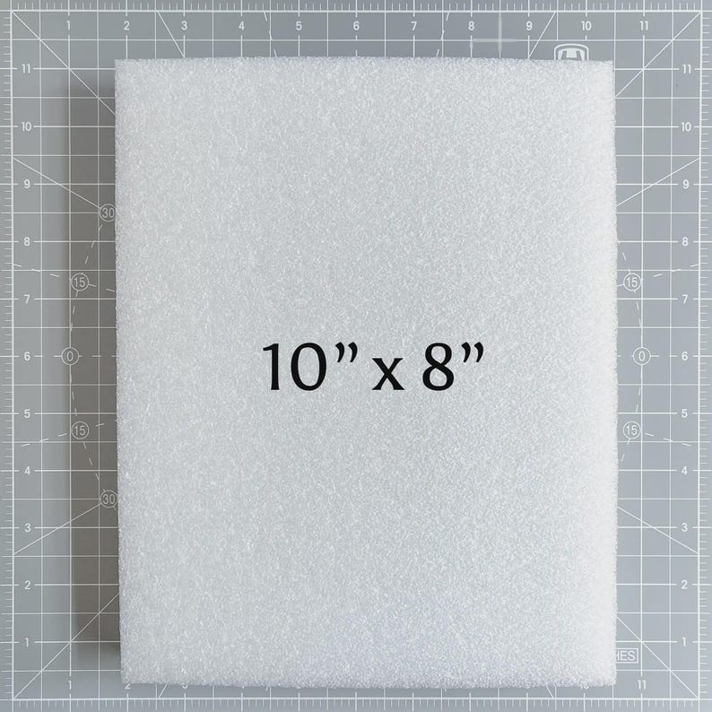 May include: A white foam sheet, measuring 10 inches by 8 inches, is displayed against a gray grid background. The text "10" x 8"" is prominently featured on the foam. The foam has a textured surface.