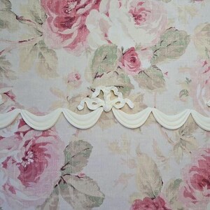 May include: White decorative trim with a scalloped edge and a floral design. The trim is made of a lightweight material and is perfect for adding a touch of elegance to any room.