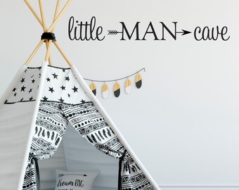 Op de afbeelding: Een zwart-witte tipi-tent met een zwart-witte gepatenteerde stof. De tent heeft een wit kussen met de tekst "Dream Big Little One". De muur achter de tent heeft een zwarte vinyl sticker met de tekst "little -MAN- cave".