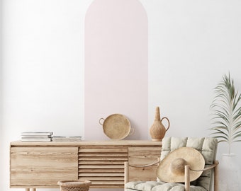 Puede incluir: Un gran adhesivo de pared en forma de arco de color rosa pálido aplicado sobre una pared blanca. El adhesivo presenta un acabado liso de color sólido y una parte superior redondeada, creando una forma arquitectónica distinta en la pared.