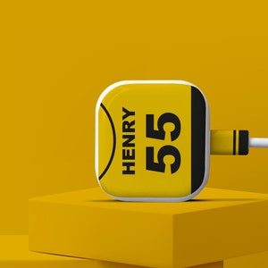 May include: A yellow phone charger with a white border and black text that says "HENRY 55".