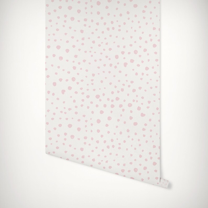 May include: Pink polka dot wallpaper with a white background. The wallpaper is rolled up and ready to be hung.