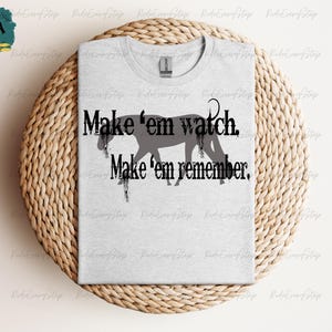 Könnte beinhalten: Ein graues T-Shirt mit einer schwarzen Silhouette eines Pferdes und dem Text "Make 'em watch. Make 'em remember."