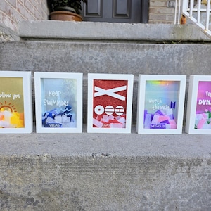 Op de afbeelding: Vijf witte schaduwbox-lijsten met kleurrijke confetti en tekst. De lijsten bevatten zinnen zoals I'll follow you, Keep SWIMMING, Vegas 2022, worth the wait en Vegas was DYNAMITE, met diverse grafische iconen zoals een zon en golven.