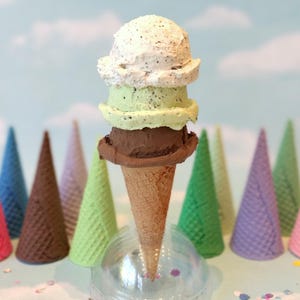 Cono de helado falso: tres bolas de helado de menta con trocitos de chocolate y galletas con crema. Gofre de azúcar de utilería.