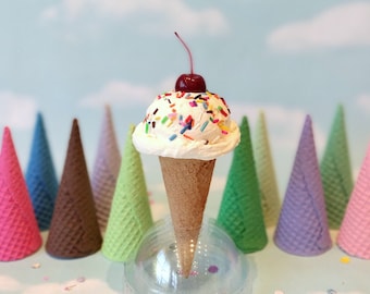 Helado falso: Una bola de vainilla con chispas de colores y cereza, en cono de gofre de azúcar.
