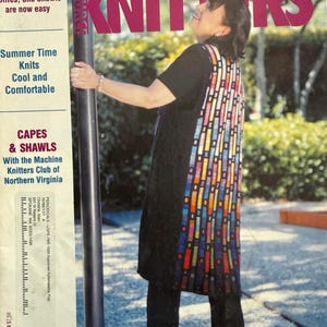 May include: A magazine cover titled Machine Knitters Source featuring a person wearing a black tunic with a vertical panel of colorful rectangular patterns. The cover includes text about charting circles, summer knits, and capes and shawls.