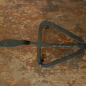 Antique geometric wrought-iron triangular trivet with handle
