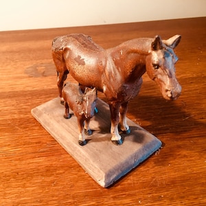 Hubley cast iron horse and colt paperweight with wood base, has wear