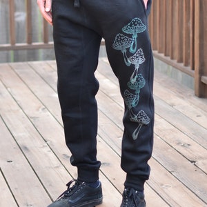 Pantaloni da jogging unisex con motivo a funghi fosforescenti – disegnati a mano
