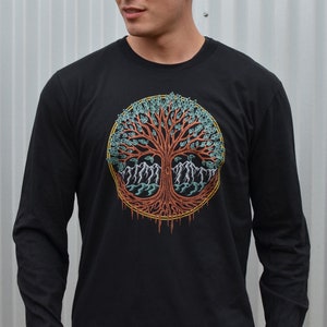 May include: A black long-sleeve t-shirt with a colorful tree of life design. The tree has a red trunk, green leaves, and blue mountains at its base.