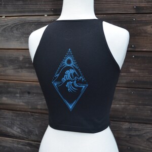 May include: Black tank top with a blue graphic of a sun, waves, and a diamond shape on the back.