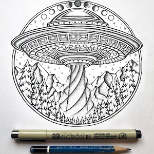May include: Black and white illustration of a UFO hovering over a mountain range with pine trees. The design is circular, with stars and phases of the moon. A Micron 01 pen and a blue pencil are below the illustration.