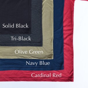 May include: Five different colored t-shirts stacked on top of each other. The colors are solid black, tri-black, olive green, navy blue, and cardinal red. The t-shirts are all the same style and size.