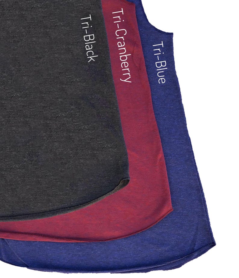May include: Three sleeveless shirts in a layered display. The shirts are in shades of Tri-Black, Tri-Cranberry, and Tri-Blue. Each shirt has a curved hemline. The names of the colours are printed vertically on each shirt.