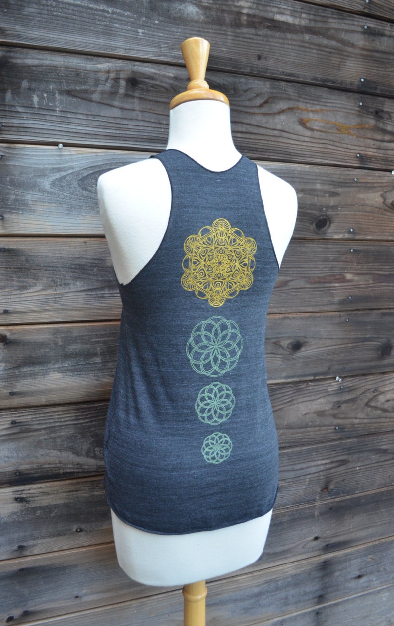 Peut inclure: D&eacute;bardeur dos nageur gris fonc&eacute; avec une s&eacute;rie de motifs floraux mandala dor&eacute;s et verts. Le d&eacute;bardeur est pr&eacute;sent&eacute; sur un mannequin devant un fond en bois.
