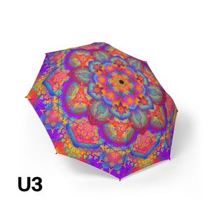 May include: A collapsible umbrella featuring a vibrant, multi-colored mandala pattern. The design incorporates intricate geometric shapes and floral-like motifs in shades of bright purple, neon orange, electric blue, and hot pink. The text U3 is visible.