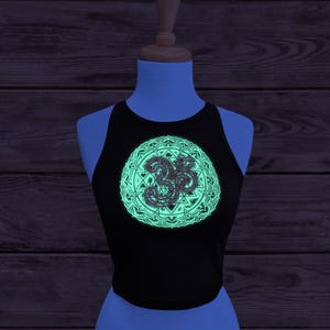 Glow in the dark Sri Yantra crop top. Image taken under UV light to show the glow in the dark layer how it could appear for music festivals or events!