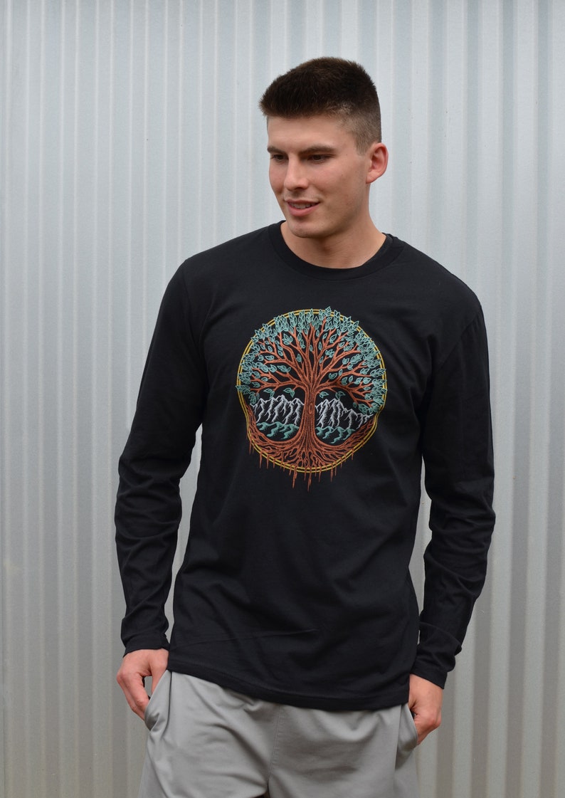May include: A black long-sleeve shirt with a colorful tree of life design on the front. The tree has a red trunk, green leaves, and blue roots.