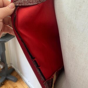 May include: A red and gold sequined dress with a zipper closure. The dress has a red lining and is shown on a white mannequin.
