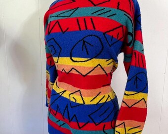 May include: A colourful striped jumper with a geometric pattern in black. The jumper is made of a soft, fuzzy material and has long sleeves. The colours are red, blue, yellow, orange, and green.