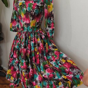 May include: A vintage dress with a colorful abstract print in shades of pink, green, yellow, and blue. The dress has a fitted bodice and a full skirt.