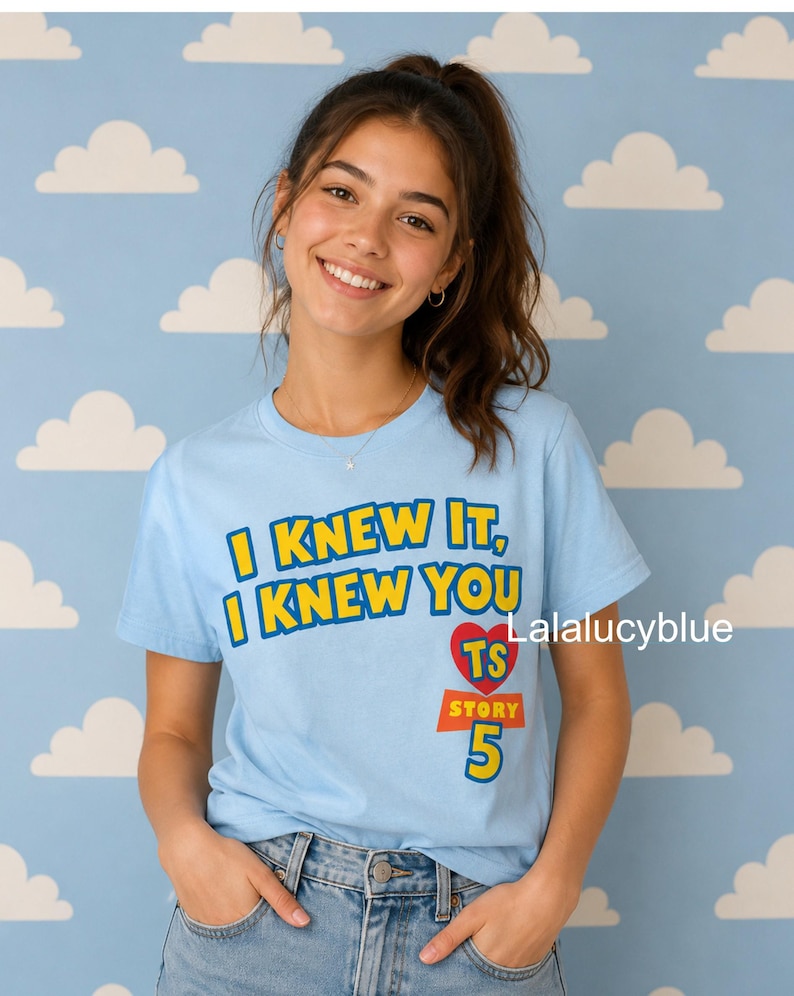 Puede incluir: Una camiseta de manga corta de color azul claro con el texto amarillo I KNEW IT, I KNEW YOU sobre un coraz&oacute;n rojo que contiene las letras TS, con la palabra STORY y el n&uacute;mero 5 impresos en amarillo debajo del coraz&oacute;n.