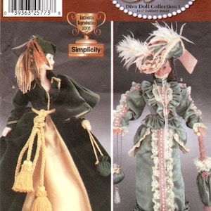 May include: Simplicity pattern 7213 for a Diva Doll Collection I, featuring two 11 1/2 inch fashion dolls. One doll wears a green velvet dress with a gold sash and a feathered hat. The other doll wears a green dress with lace trim and a pink sash, and a white feathered hat.