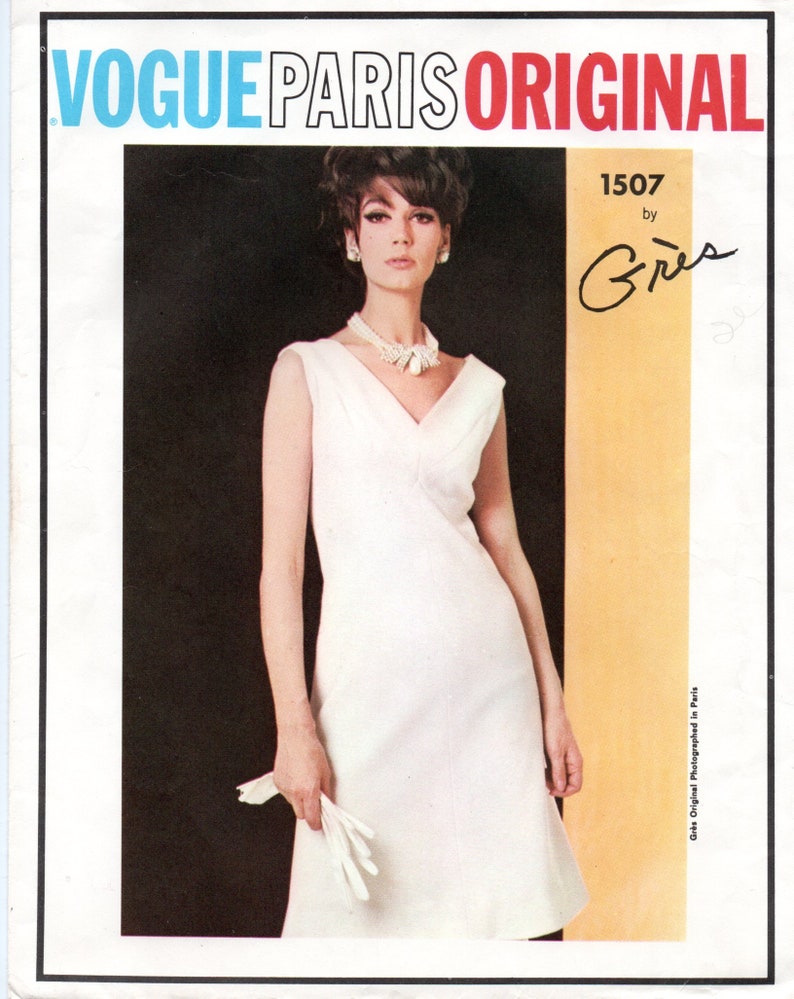 Puede incluir: Ilustraci&oacute;n de moda vintage de Vogue Paris Original. La imagen presenta a una mujer con un vestido blanco sin mangas, sosteniendo guantes blancos. El texto en la parte superior dice "Vogue Paris Original". El vestido tiene cuello en V y falda ligeramente acampanada.