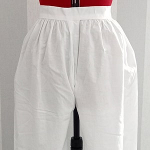 May include: White cotton bloomers on a dress form. The bloomers have a gathered waistband and are fitted through the legs.