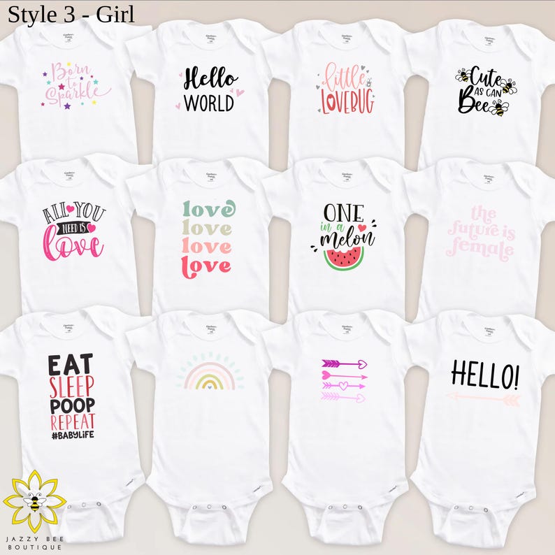 Pu&ograve; includere: Body per neonati bianchi con vari disegni grafici e testo colorati. I disegni includono frasi come "Born to Sparkle", "Hello World", "Little Lovebug" e "Eat Sleep Poop Repeat". L'immagine include anche un logo per Jazzy Bee Boutique.