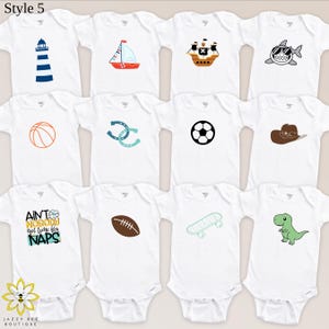 Pu&ograve; includere: Body bianchi per neonati con vari disegni colorati, tra cui un faro, una barca a vela, una nave pirata, uno squalo, un pallone da basket, ferri di cavallo, un pallone da calcio, un cappello da cowboy, un pallone da football americano, uno skateboard e un dinosauro. &Egrave; presente anche il testo "Ain't nobody got time for naps".