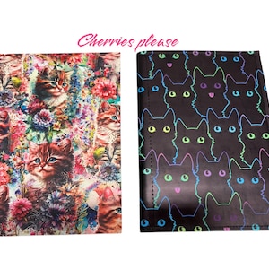 May include: Two notebooks. One features a floral pattern with kittens. The other has a black background with neon cat outlines. The text "Cherries please" is written in pink cursive above the notebooks.