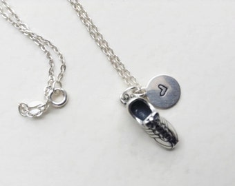 May include: A silver necklace with a shoe charm and a small heart charm. The necklace is on a white background.