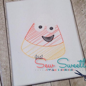 May include: Embroidered design of a candy corn with a smiling face and googly eyes. The design is stitched in red, yellow, and white thread. The text "Just Sew Sweetly - Applique & Embroidery" is below the design.