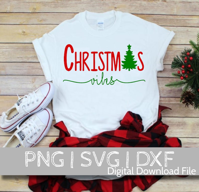 May include: White t-shirt with red text that says "Christmas vibes" and a green Christmas tree graphic.