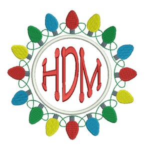 May include: A white circle with a red monogram "HDM" surrounded by a wreath of colorful Christmas lights. The lights are red, green, blue, and yellow.